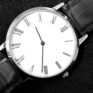 Close-up of an elegant analog wristwatch with a leather strap and Roman numerals.